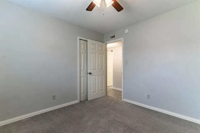 an empty room with chandelier fan