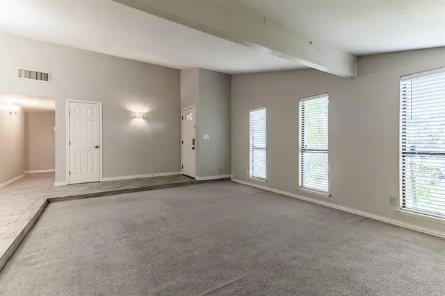 a view of an empty room with windows and closet