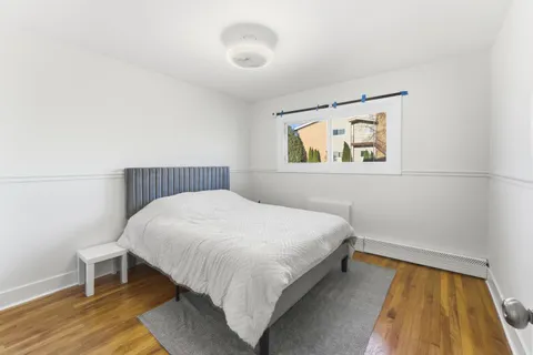 a bedroom with a bed and painting on the wall