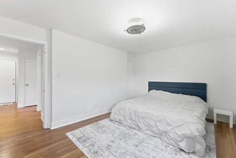 a bedroom with a bed and wooden floor