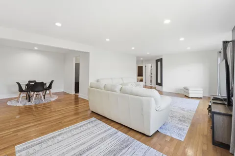 a living room with furniture a flat screen tv and a table