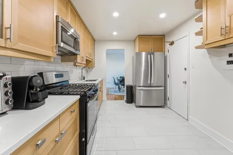 a kitchen with stainless steel appliances granite countertop a stove a refrigerator and a refrigerator