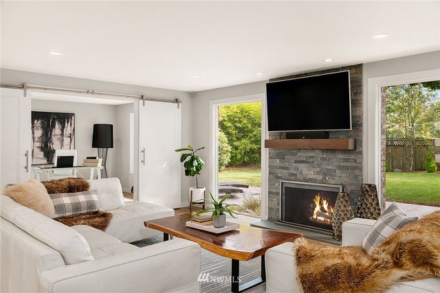 a living room with furniture a flat screen tv and a fireplace