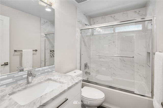 a bathroom with a granite countertop sink toilet and shower