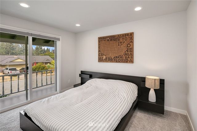 a bedroom with a bed and a large window