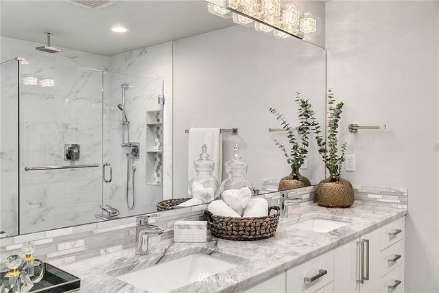 a bathroom with a granite countertop sink a toilet and shower