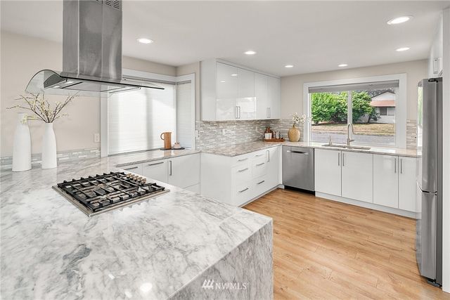 a kitchen with stainless steel appliances granite countertop a stove a sink and a refrigerator