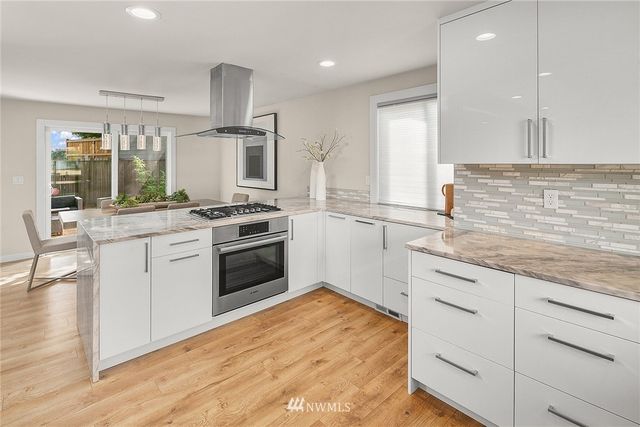 a kitchen with granite countertop a sink stainless steel appliances and cabinets
