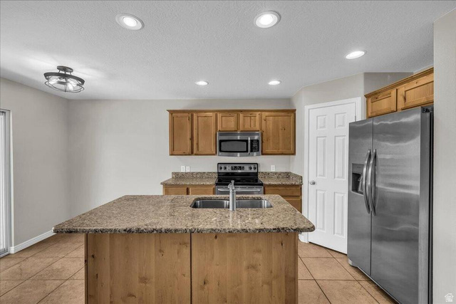 3155 South Hidden Dr Street, Unit 248 St. George, UT 84790 - Photo 6 of 24 Kitchen featuring a central island with an undermount sink, granite countertops, wood-finish cabinetry, stainless steel appliances, and recessed lighting
