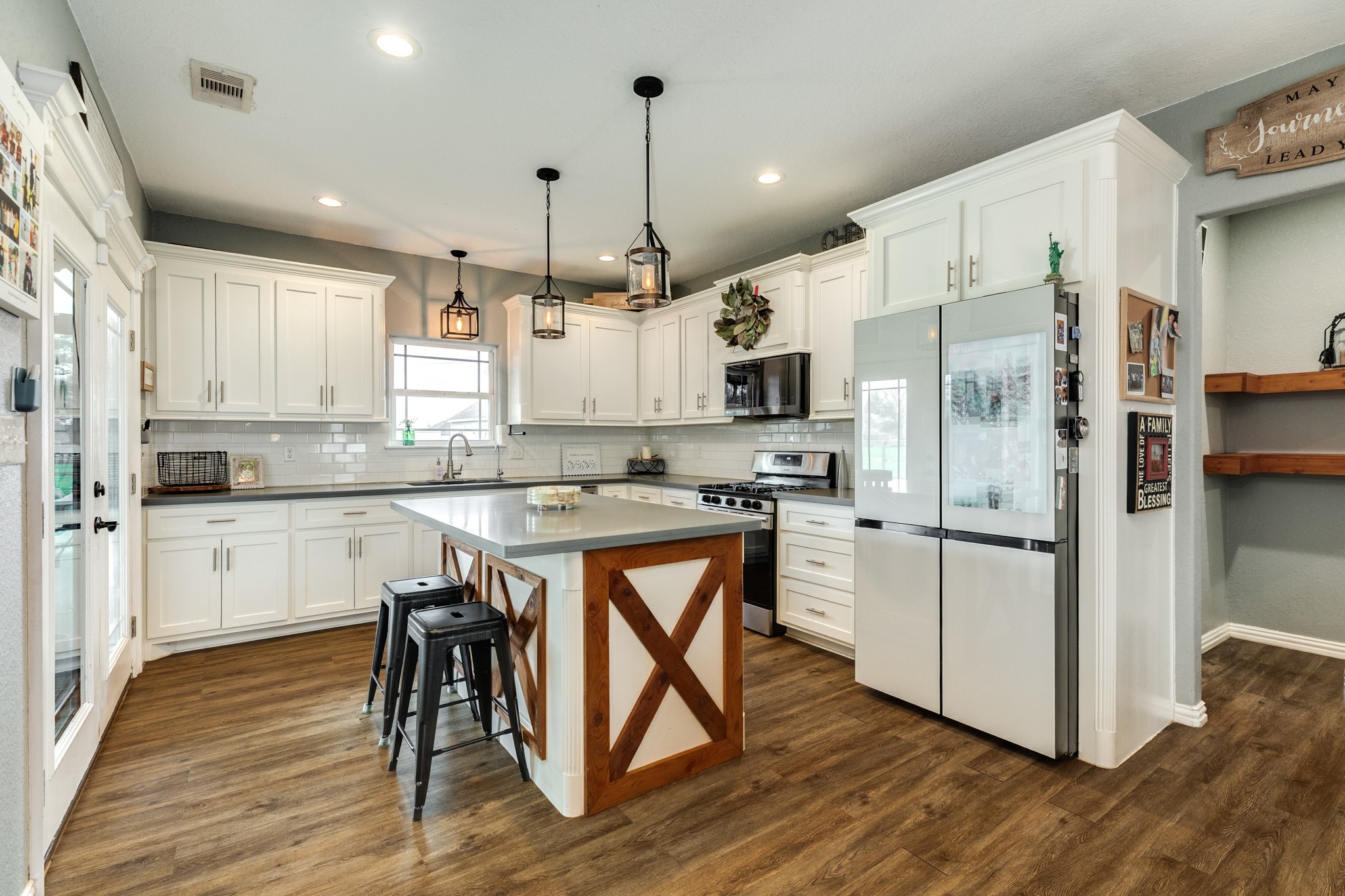 613 Winchester Trail Angleton, TX 77515 - Photo 15 of 32 a kitchen with stainless steel appliances a refrigerator a stove a sink and a dining table with wooden floor