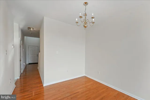a view of a chandelier in big room with wooden floor
