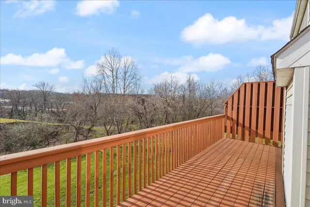 a balcony with view of roof and wooden floor