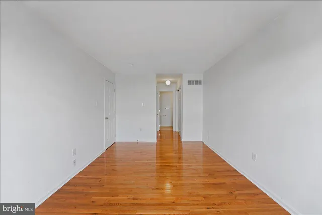 a view of an empty room with wooden floor