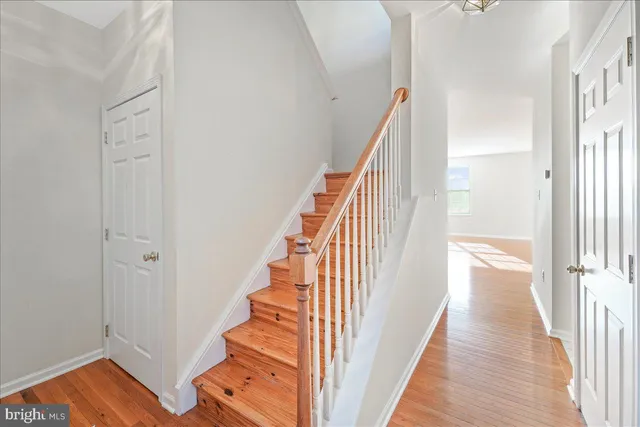 a view of a hallway with wooden floor and staircase