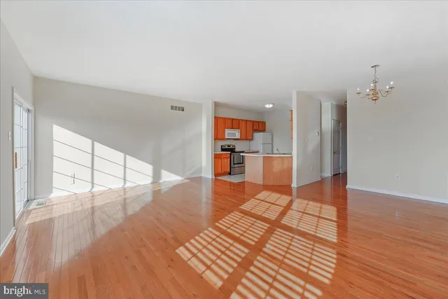 a view of a living room with wooden floor and a large window