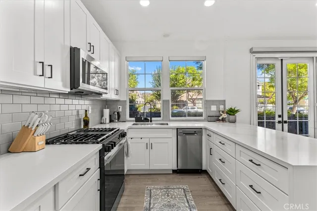 a kitchen with cabinets appliances a sink and a window