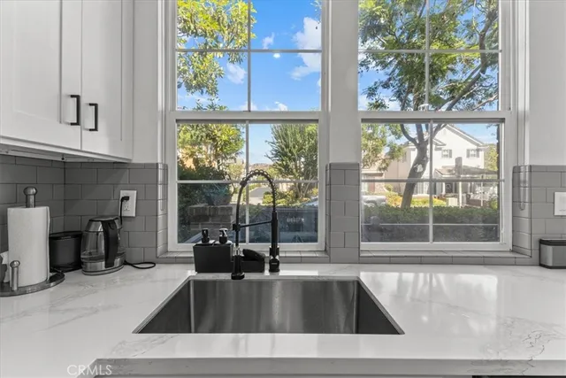 a view of a kitchen with a sink and large window