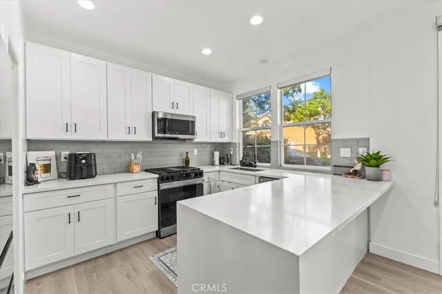 a kitchen with stainless steel appliances granite countertop a sink a stove and microwave