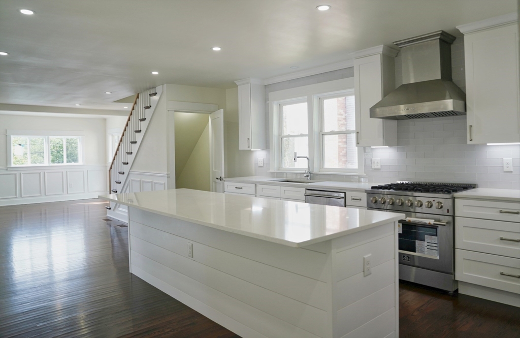 281 Forest Street Arlington, MA 02474 - Photo 6 of 26 a large kitchen with granite countertop a stove and a sink