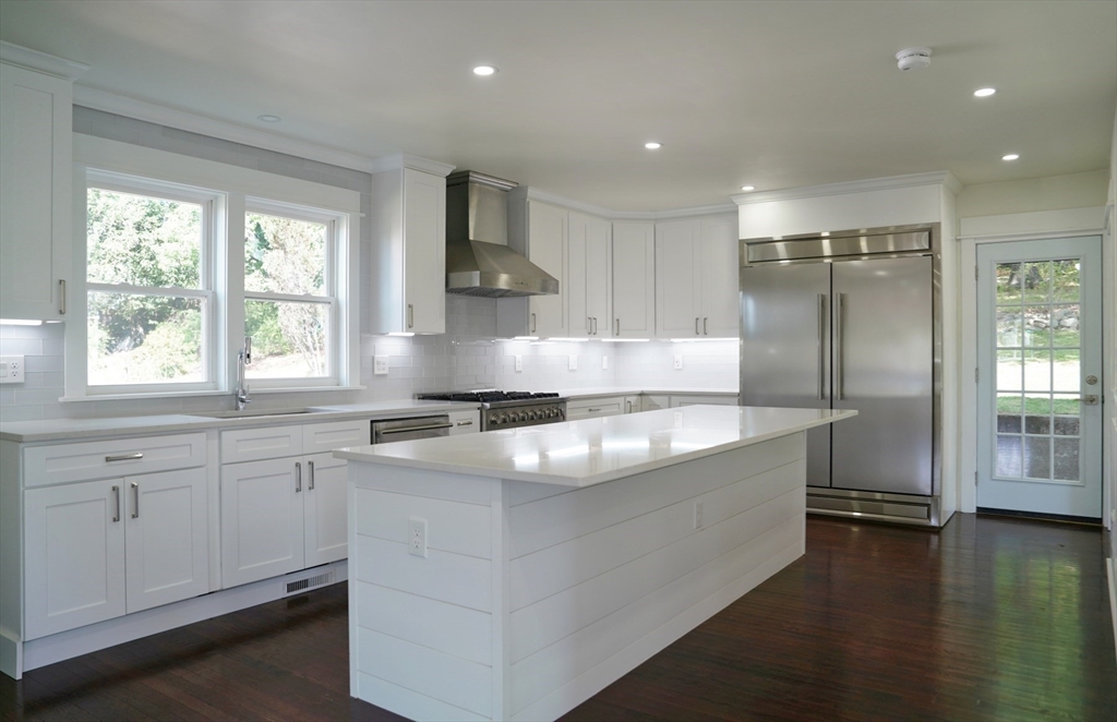 281 Forest Street Arlington, MA 02474 - Photo 7 of 26 a kitchen with kitchen island granite countertop a sink stove and refrigerator