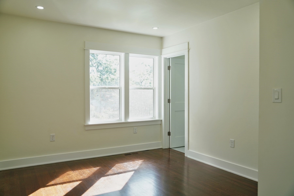281 Forest Street Arlington, MA 02474 - Photo 9 of 26 an empty room with wooden floor and windows