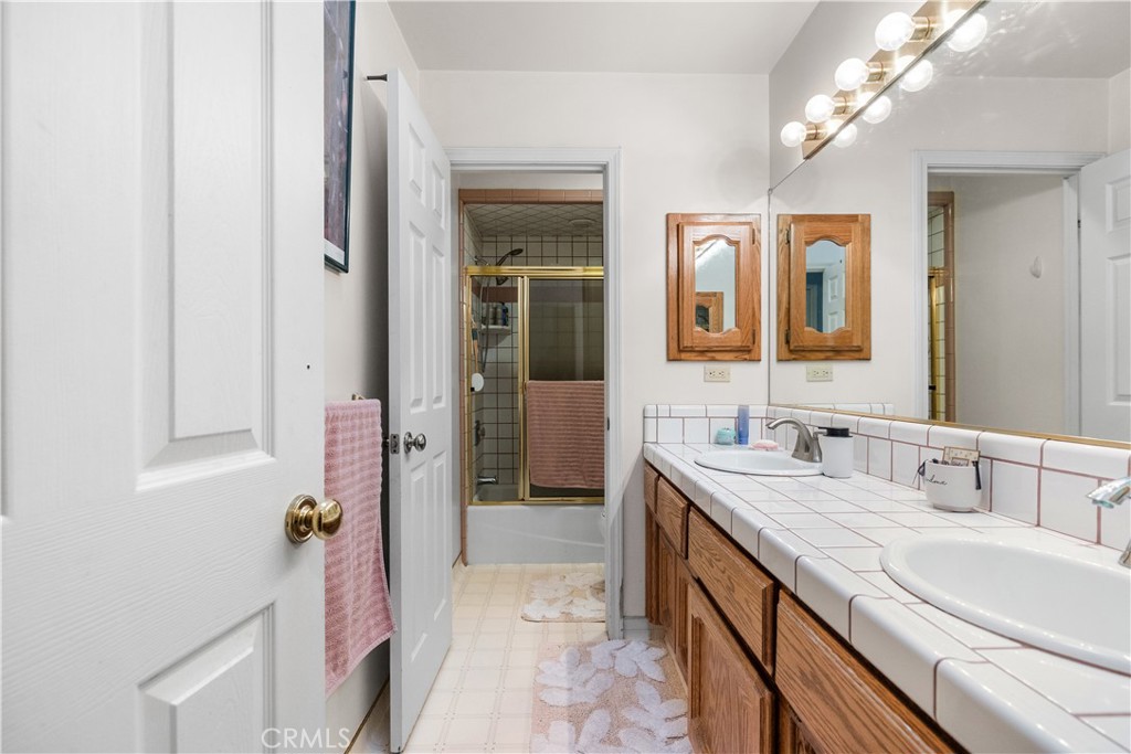 18888 Pellisier Road Tehachapi, CA 93561 - Photo 25 of 43 a spacious bathroom with a double vanity sink a large mirror and shower