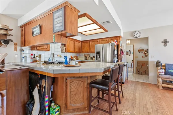 a dining hall with stainless steel appliances kitchen island granite countertop a table and chairs in it