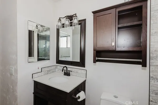 a bathroom with a sink a toilet and mirror