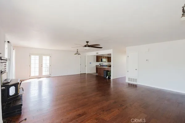 a view of empty room with wooden floor and fireplace