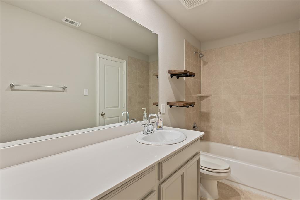 6909 Danridge Road Rowlett, TX 75089 - Photo 18 of 29 a bathroom with a sink a toilet and shower