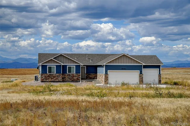 a front view of house with yard and trees in the background