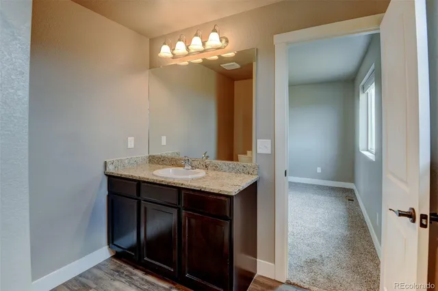 a bathroom with a sink a light fixture and a mirror