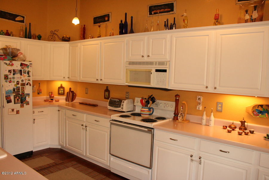 5926 East Grandview Road Scottsdale, AZ 85254 - Photo 12 of 18 a kitchen with stainless steel appliances granite countertop a sink and cabinets with wooden floor