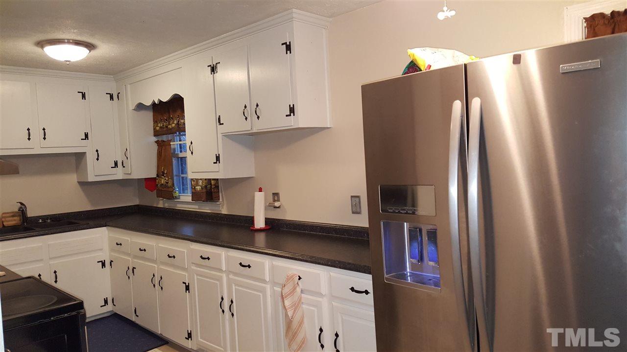 5105 Clearview Street Raleigh, NC 27603 - Photo 3 of 5 a kitchen with stainless steel appliances a refrigerator a sink and white cabinets