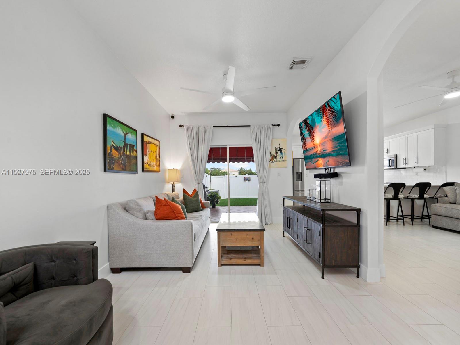 12881 Southwest 49th Court, Unit 12881 Miramar, FL 33027 - Photo 1 of 47 a living room with furniture and a flat screen tv