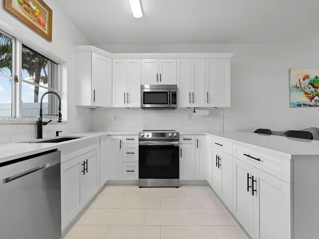 a kitchen with stainless steel appliances granite countertop a stove and a sink