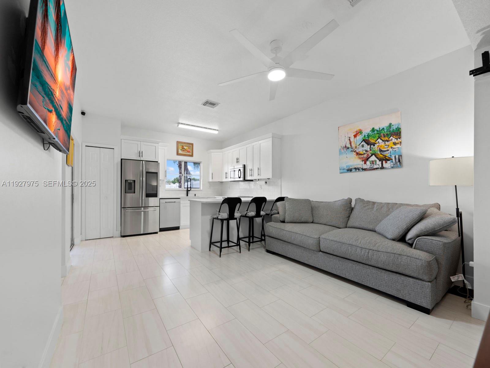 12881 Southwest 49th Court, Unit 12881 Miramar, FL 33027 - Photo 14 of 47 a living room with stainless steel appliances furniture and a kitchen view