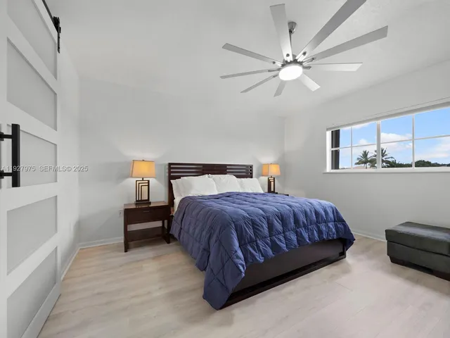 a spacious bedroom with a bed a couch and a chandelier