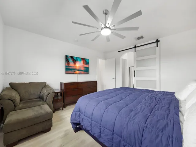 a bedroom with a bed couch and dresser