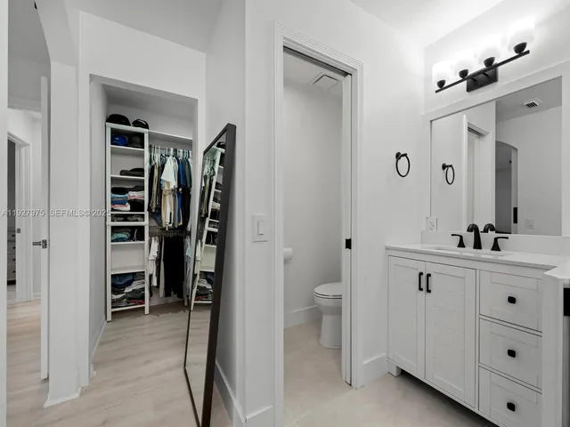 a bathroom with a double vanity sink a toilet and a mirror