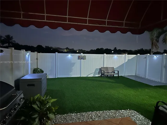 a backyard of a house with table and chairs