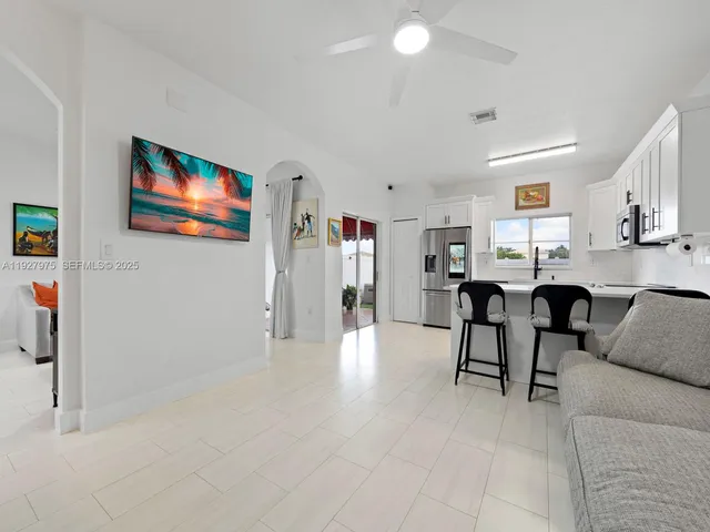 a living room with furniture and kitchen view