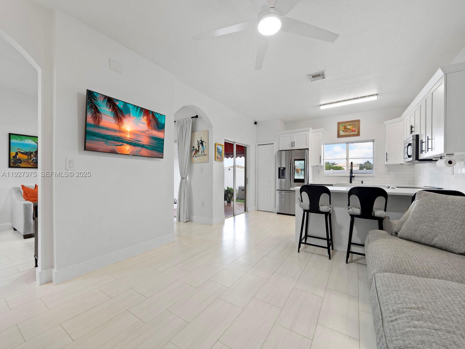 12881 Southwest 49th Court, Unit 12881 Miramar, FL 33027 - Photo 10 of 47 a living room with furniture and kitchen view