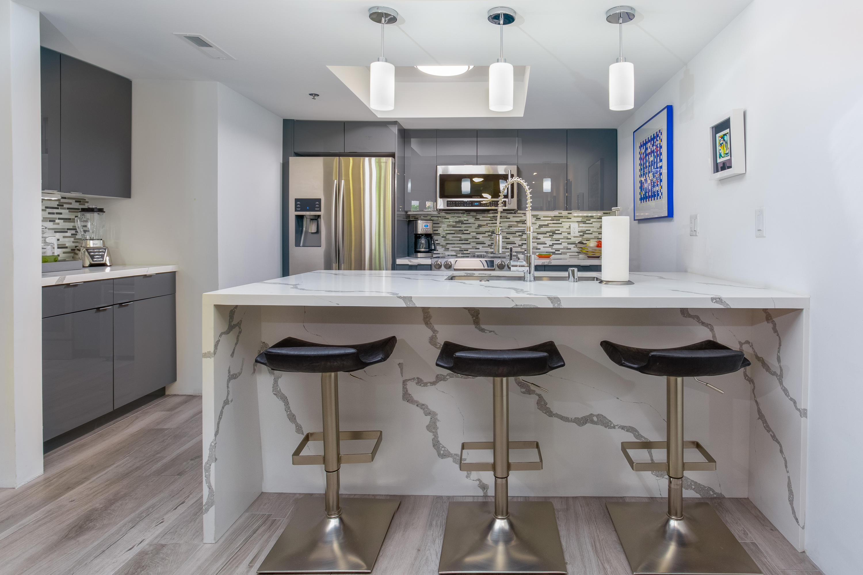 500 East Amado Road, Unit 111 Palm Springs, CA 92262 - Photo 14 of 48 a kitchen with stainless steel appliances a dining table chairs and wooden floor