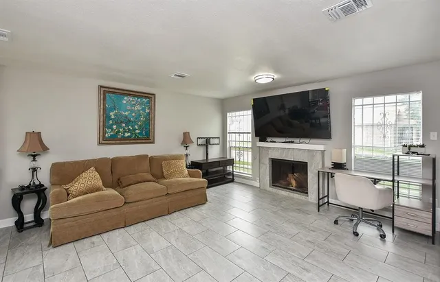 a living room with furniture a fireplace and a flat screen tv
