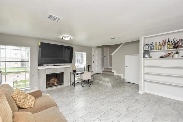 a living room with furniture a flat screen tv and a fireplace