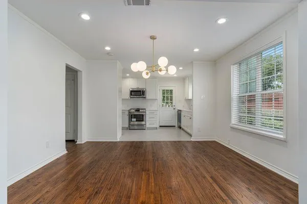 a kitchen with stainless steel appliances granite countertop a dishwasher a stove a refrigerator with wooden floors and cabinets