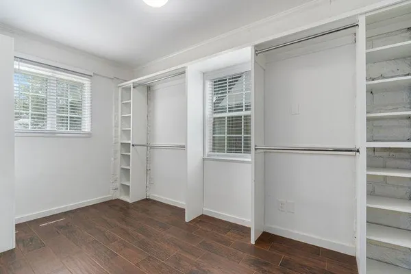 a view of empty room with wooden floor and window