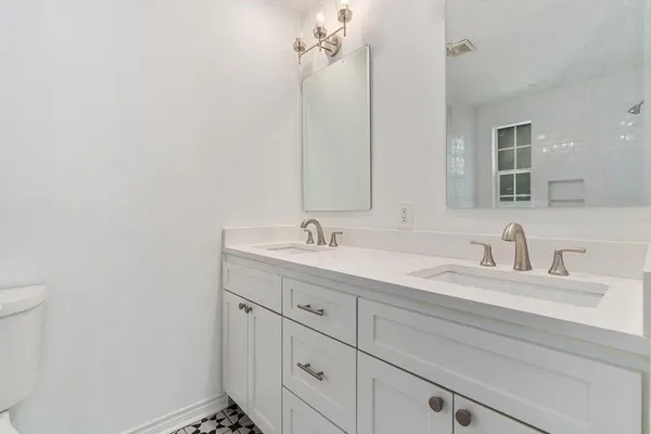 a bathroom with a double vanity sink and a mirror