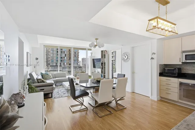 a living room with furniture a rug and kitchen view